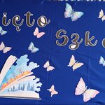 Granatowa dekoracja z napisem „Święto Szkoły”, motylami oraz ilustracją otwartej książki przygotowana z okazji uroczystości w SP12 im. Zygmunta Glogera w Białymstoku.