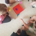  Dzieci wykonują zabawy oddechowe z piórkami
