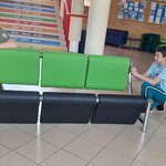 Dwie osoby podczas montażu czarno-zielonego mebla.jpg