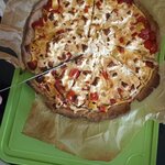 Wytrawna tarta pokrojona na kawałki leży na papierze do pieczenia na zielonej desce widocz.jpg