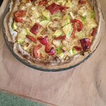 Wytrawna tarta w szklanej formie stoi na drewnianym blacie na wierzchu cukinia_ papryka i .jpg