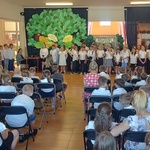 Publiczność siedząca na rzędach czarnych krzeseł ustawionych w kierunku sceny.jpg