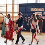 Uczniowie w strojach galowych niosą sztandar szkoły podczas ceremonii..JPG