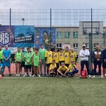 Uczestnicy szkolnych zawodów sportowych wraz z opiekunami podczas wspólnego zdjęcia na boisku..jpeg