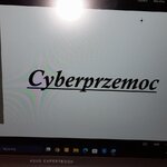 Grafika przedstawiająca smartfon z obraźliwym komentarzem w mediach społecznościowych oraz napis „Cyberprzemoc”.