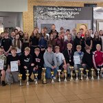 Grupa uczniów i nauczycieli prezentuje puchary_ medale oraz dyplomy zdobyte podczas międzyszkolnej rywalizacji sportowej..jpg