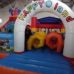 Kolorowy dmuchany plac zabaw z napisem „Happyland”, przygotowany dla dzieci.