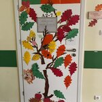 Drzwi klasowe ozdobione papierowym „Drzewem dobrych słów” z kolorowymi liśćmi zawierającymi życzliwe hasła i pozdrowienia.