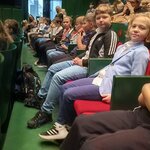 Widownia wypełniona dziećmi i opiekunami na pierwszym planie uczestnicy siedzący w fotelac.jpg