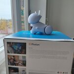 Robot: „Biało-niebieski robot edukacyjny Photon ustawiony na pudełku przy oknie.”