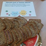 Talerz z ciemnym pieczywem z ziarnami oraz kartka z radami o myciu rąk.jpg