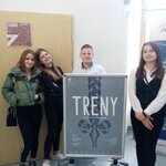 Uczniowie stoją przy plakacie.
