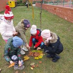Pięcioro dzieci układa kompozycję z darów jesieni w pobliżu boiska.jpg