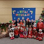 Grupowe zdjęcie grupy Motylków. Dzieci są ubrane w świąteczne swetry oraz czapki mikołajow.jpg
