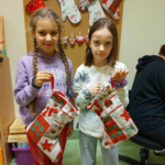 Dwie dziewczynki prezentują kolorowe skarpety.png