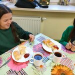 Dwie dziewczynki jedzą upieczone pasztetciki francuskie z ketchupem.jpg