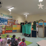 Aktor w stroju trzygłowego smoka podczas występu dla dzieci w sali przedszkolnej..jpg