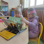 Dwie dziewczynki z grupy motylki przeglądają książkę o dinozaurach..jpg