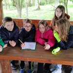 Sześcioro uczniów przy drewnianym stole rozwiązuje zadania w ramach warsztatów edukacyjnyc.jpg