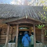Grupa uczniów wchodząca do chaty w skansenie.jpg