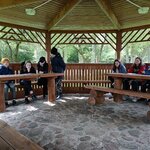 Dwie grupy uczniów siedzą przy drewnianych stołach.jpg