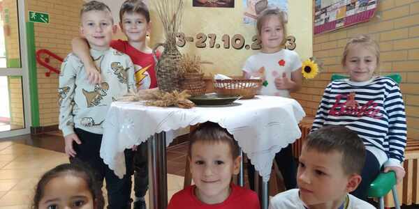Dzieci z gr. Motylki przed wystawką na szkolnym holu z okazji Tygodnia zdrowego chleba.jpg