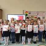 Dzieci z grupy Biedronki prezentuja swoje prace plastyczne na tle dekoracji bialo-czerwonychjpg.jpg