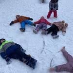 Dzieci z grupy „Pszczółek” wykonują „aniołki” na śniegu..jpg