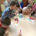 Dzieci z grupy  Motylki układające przy stole puzzle z pączkami..jpg